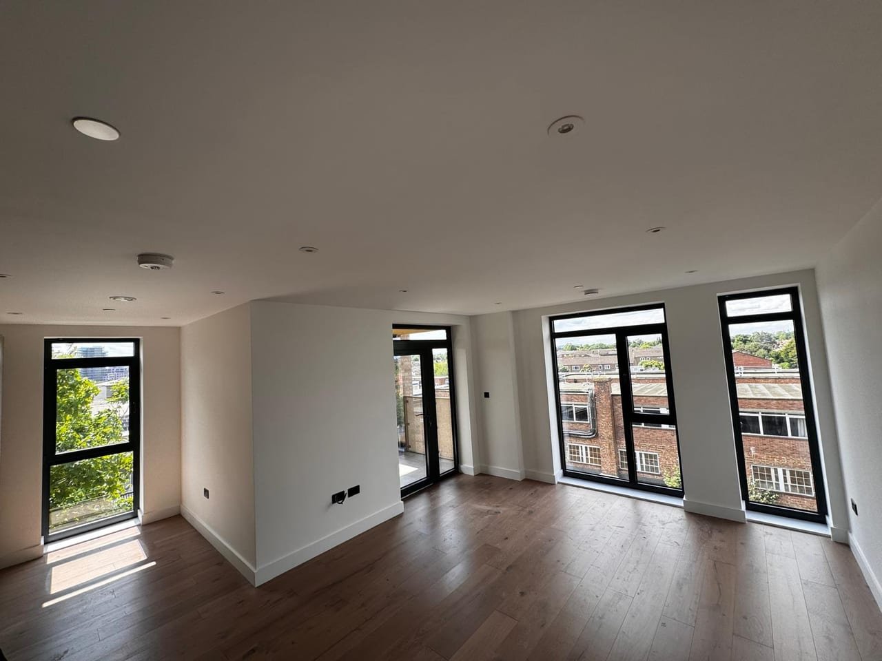 Finished room with full-height corner glazing onto a balcony